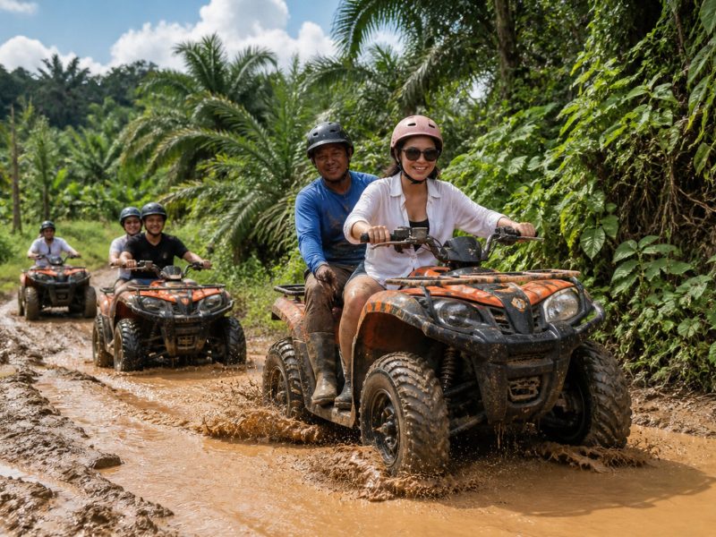 Group of riders on ATVs driving through a muddy jungle trail near Khao Lak