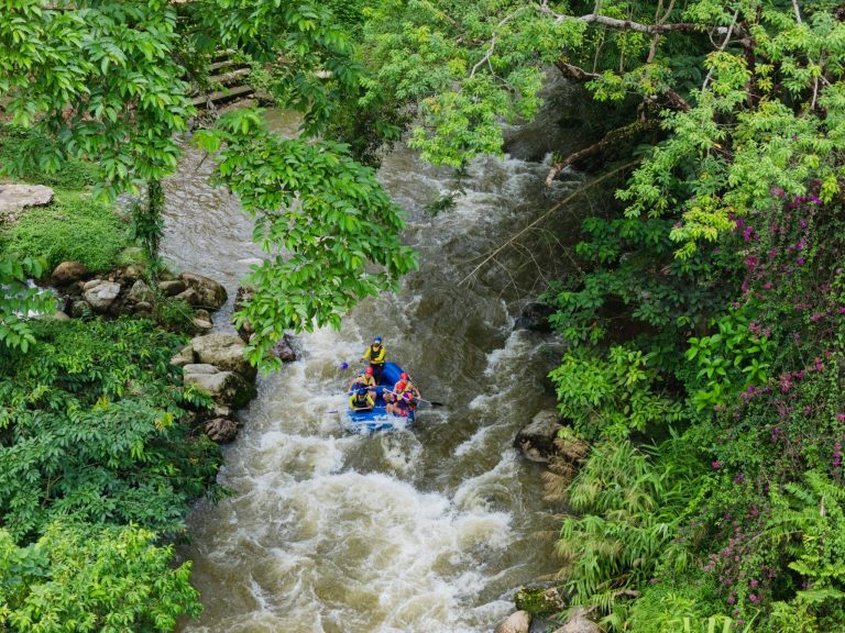 Raft on a rocky river surrounded by jungle, seen from above, in Phang Nga