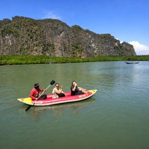 Sea canoe in Phang Nga Bay surrounded by limestone cliffs